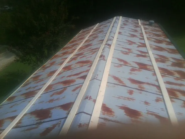 Rusted metal roof panels with new wood purlins before replacement — Storm Damage Roof Repair in Reform by Roofing Brothers