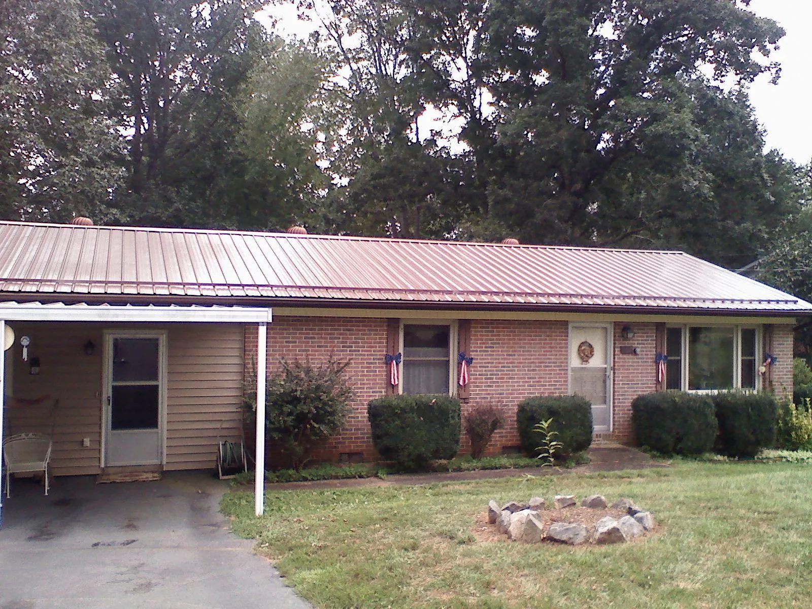 Bronze metal roof and carport on a brick ranch home — Roof Repair work by our crew in Reform