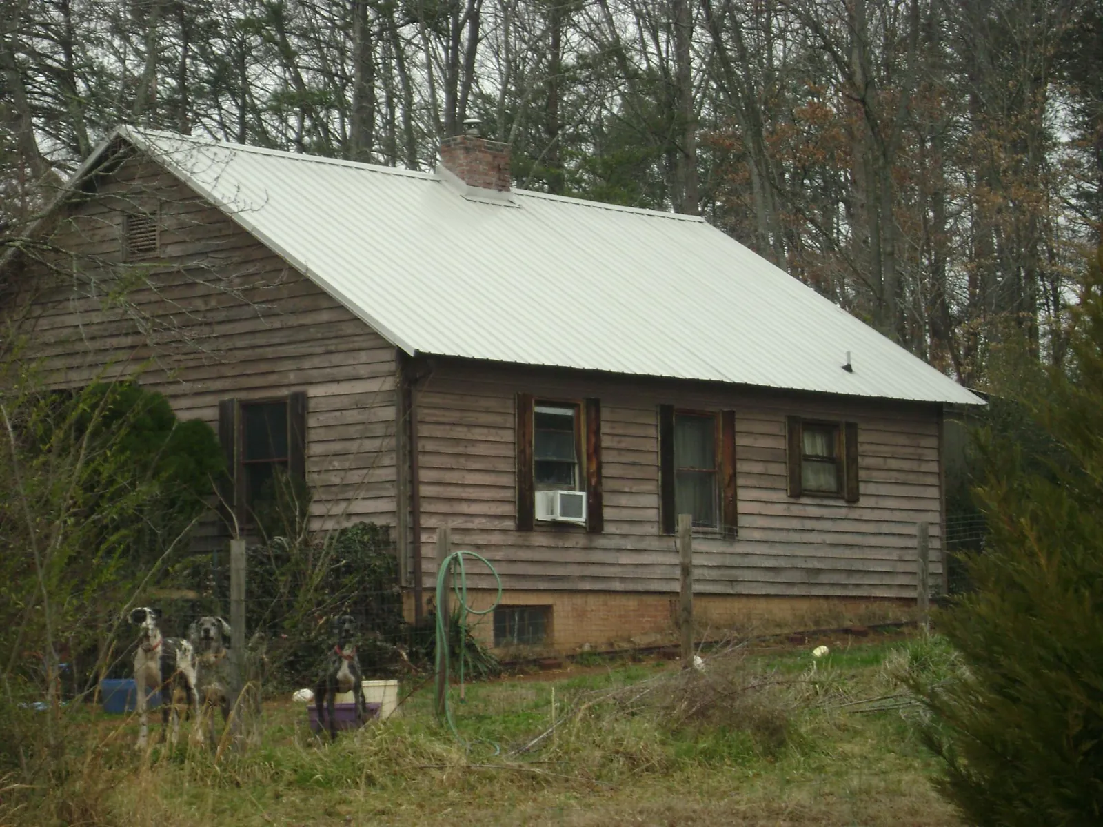 White metal roof on an old wood sided farmhouse, from a Metal Roof Installation job in Reform